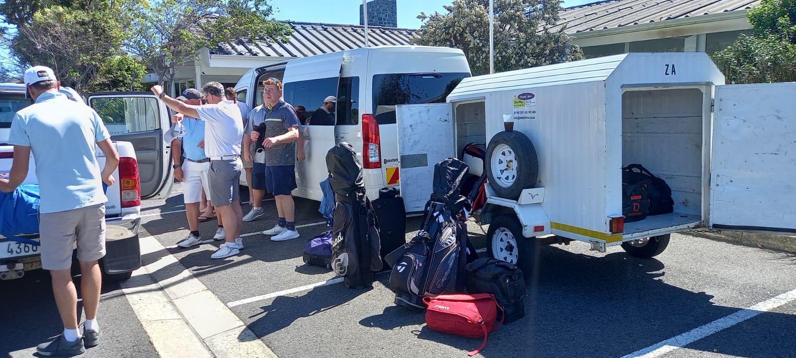Golf group loading clubs into shuttle and trailer