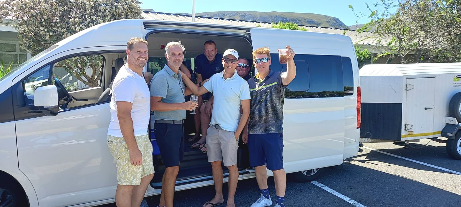 Group of guests toasting next to shuttle in Hermanus